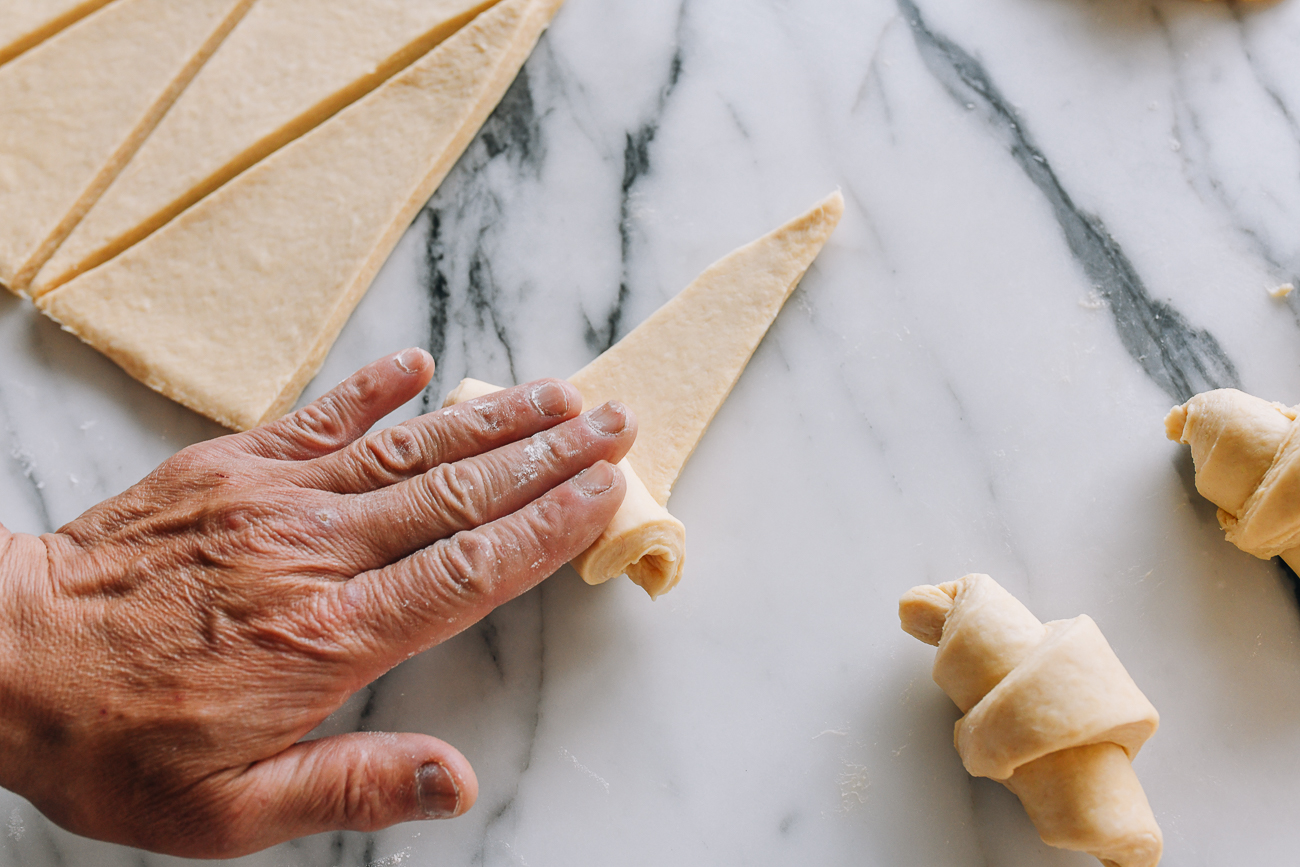 Rolling dough into croissant shape