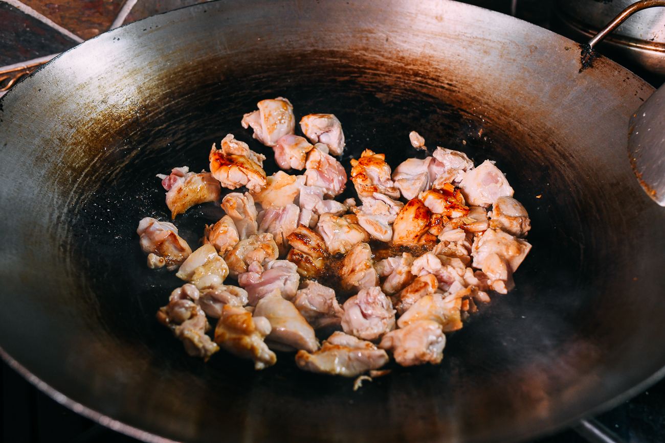 seared chicken thigh pieces in wok