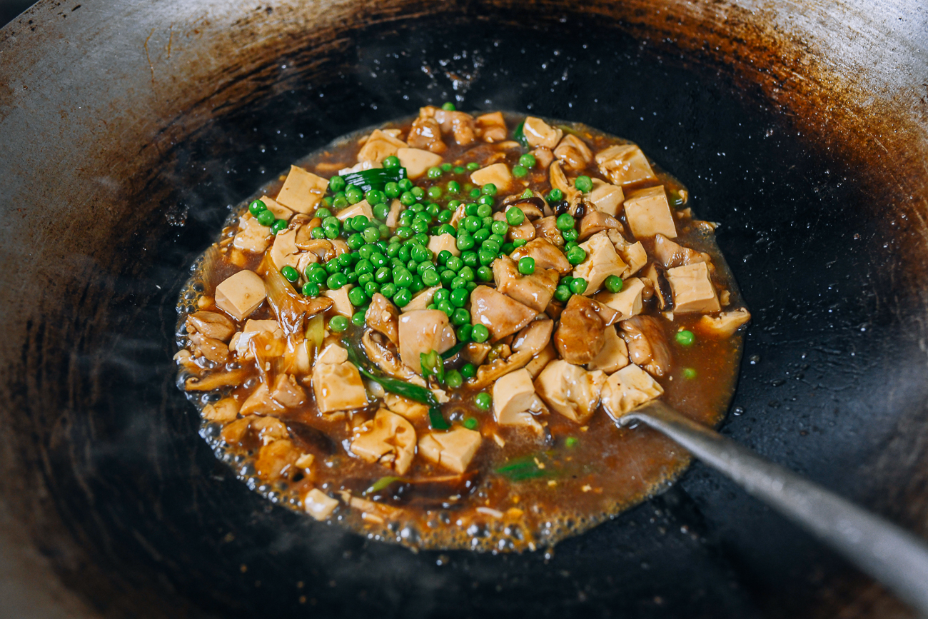 Green peas added to chicken and tofu mixture in wok
