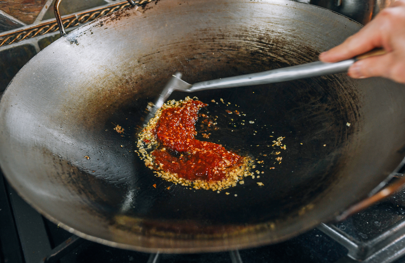 stirring chili garlic sauce in wok