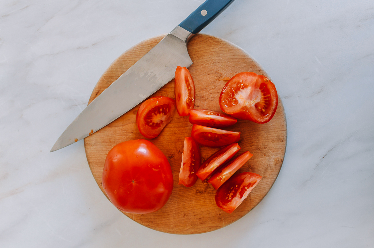 Tomatoes on cutting board cut into chunks