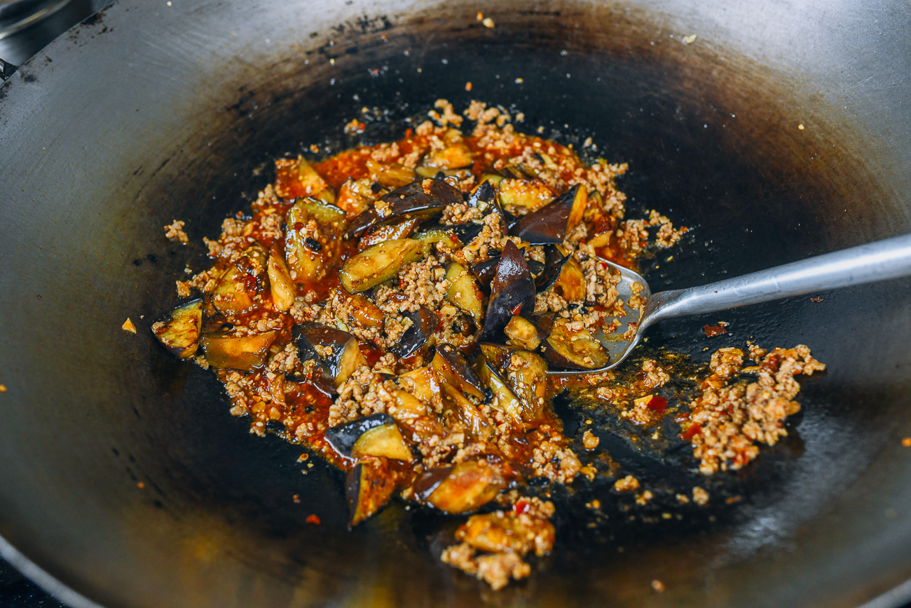 stirring eggplant into sauce