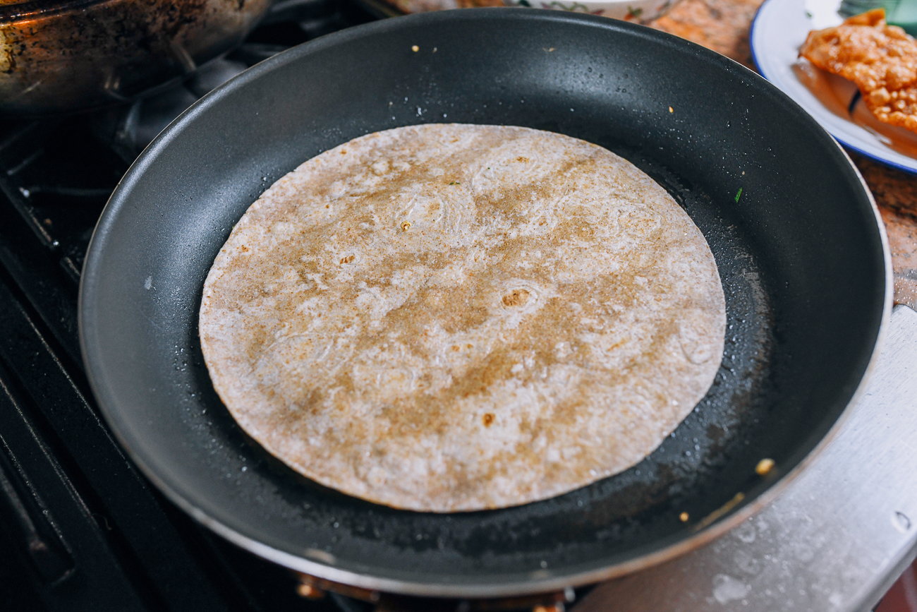 frying whole wheat tortilla in non-stick pan with oil