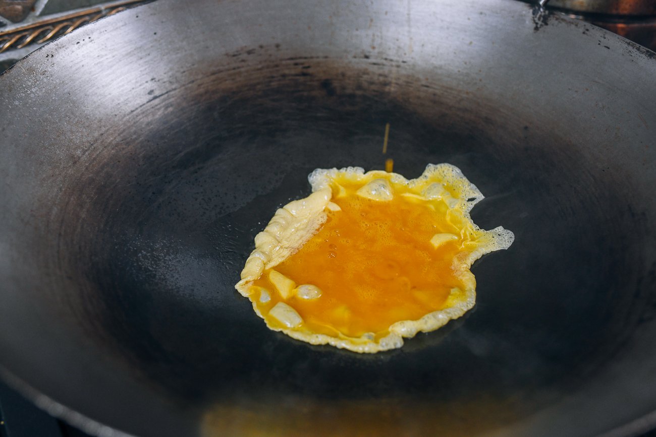 cooking beaten eggs in wok