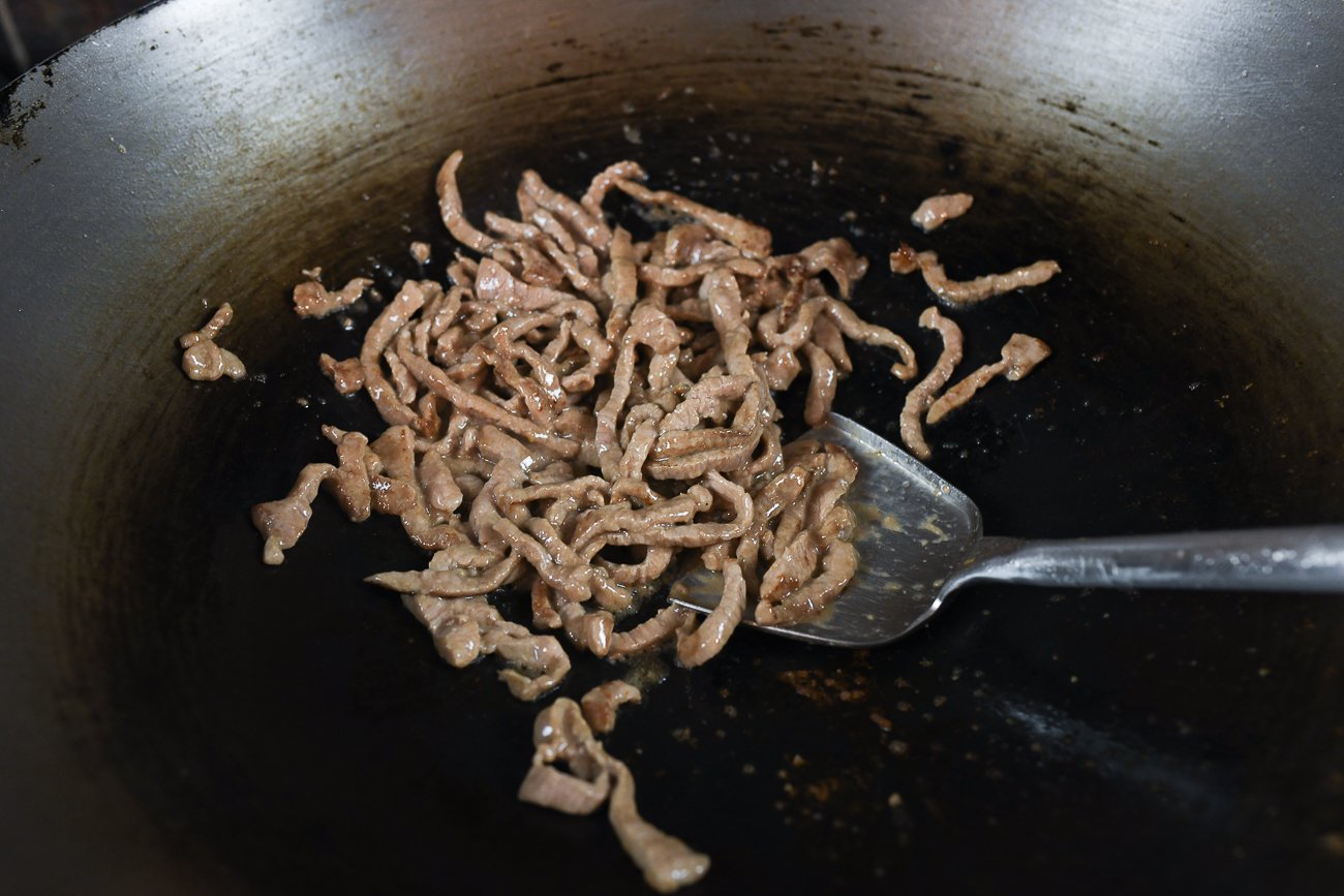 stir-frying shredded pork in wok