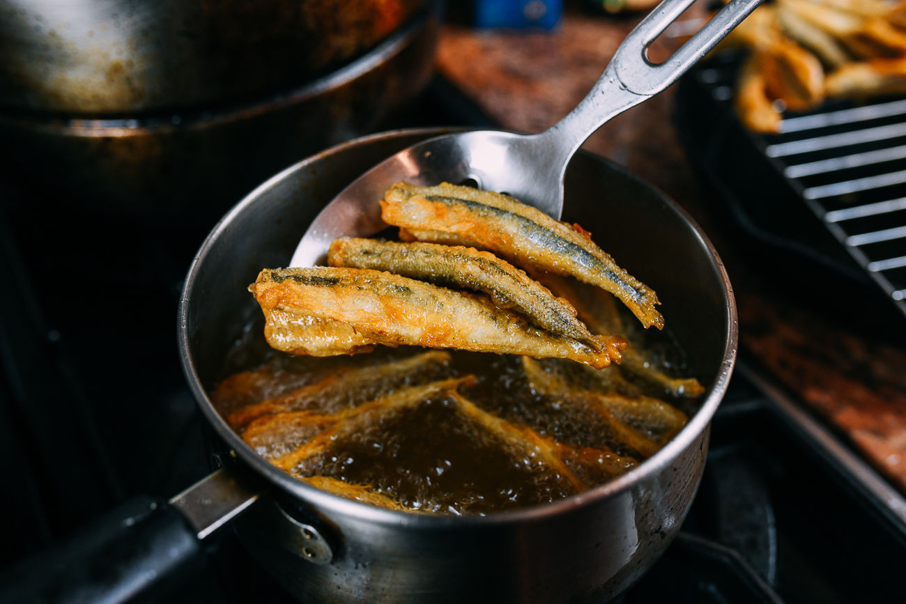 pulling fried smelts out of oil