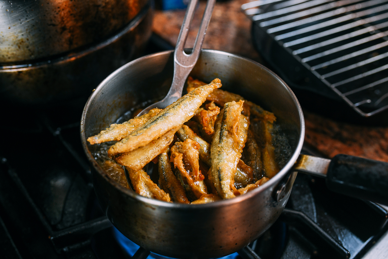 pulling fried smelts out of oil