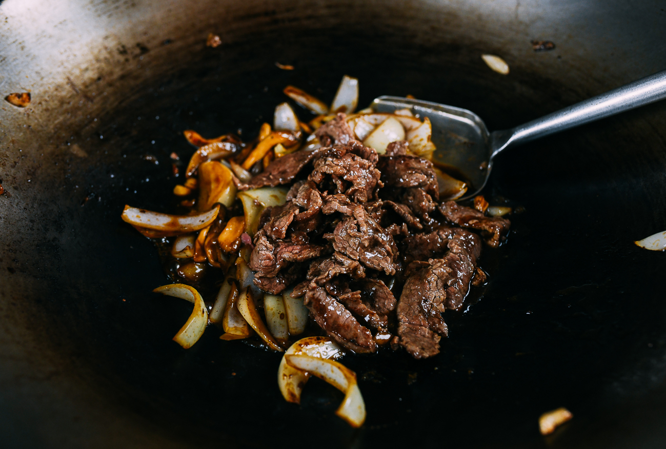 adding beef to onions and mushrooms