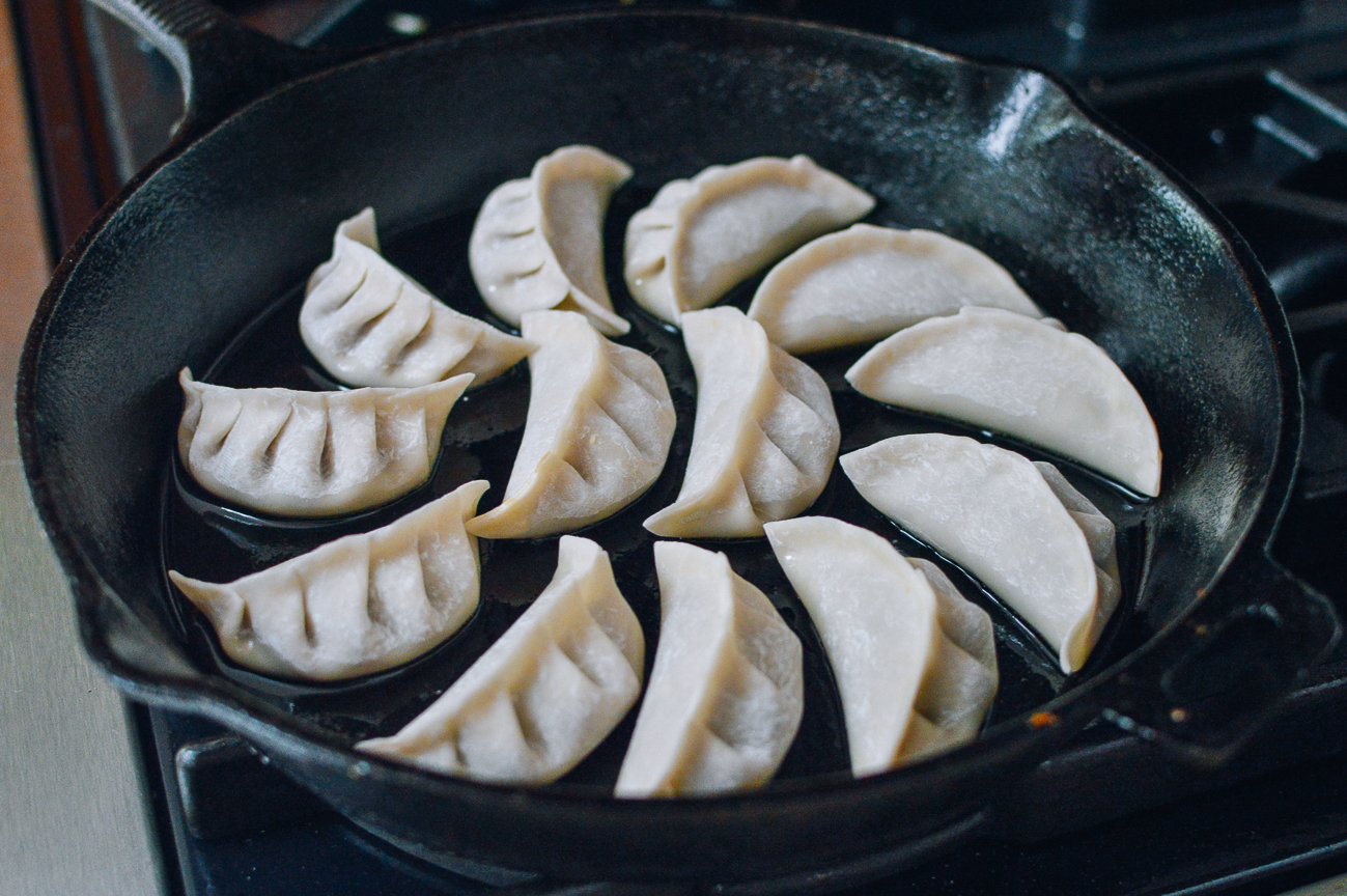 dumplings in oil in cast iron pan