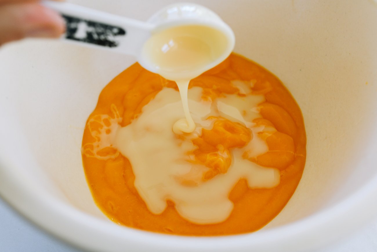 adding condensed milk to mango puree