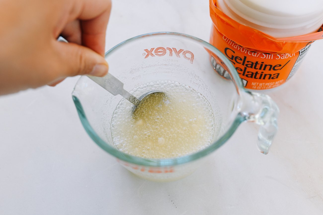stirring gelatin into water in measuring cup