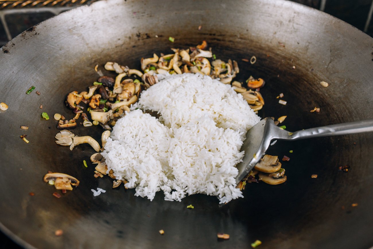 adding rice to wok