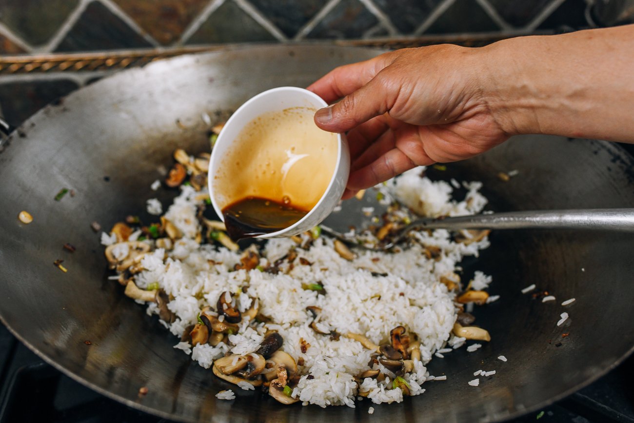adding sauce to rice in wok