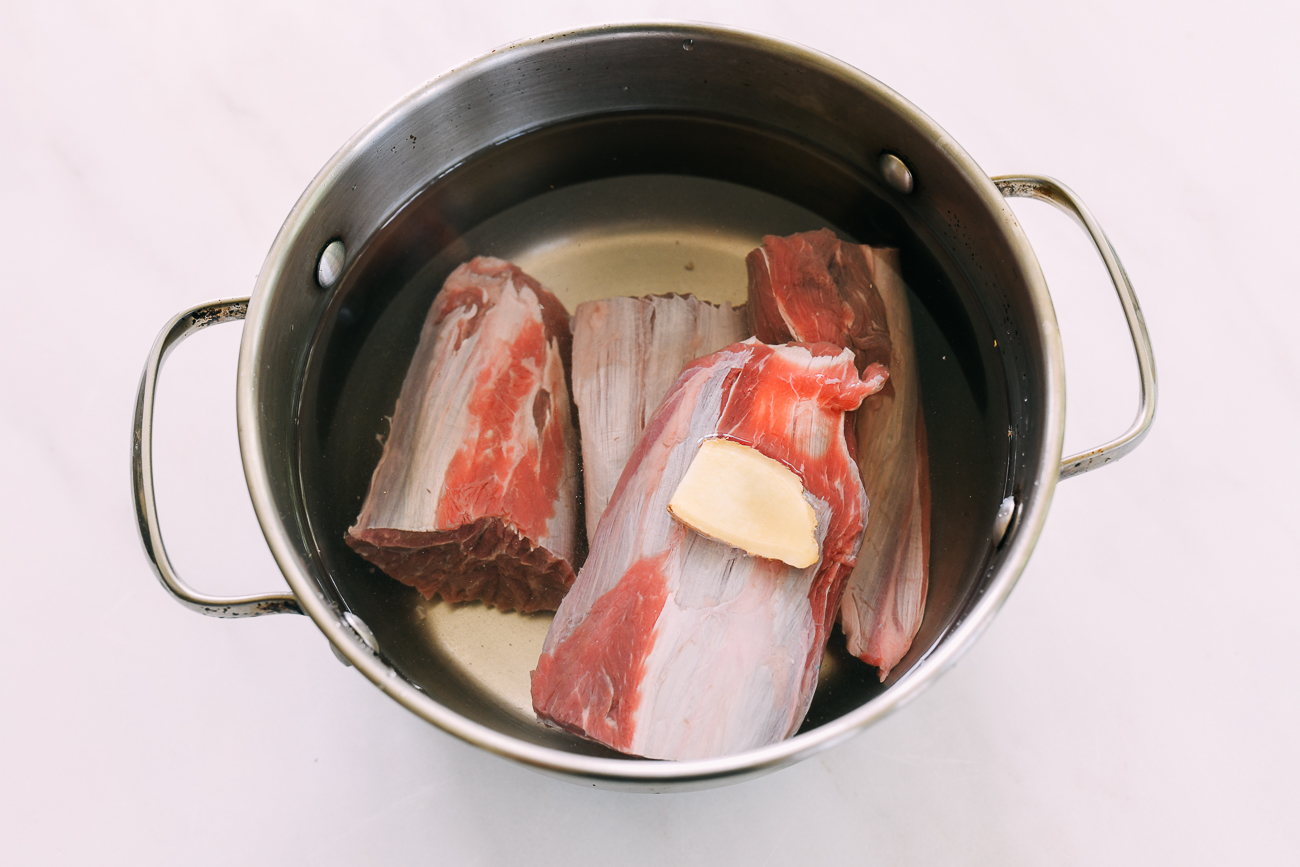 beef shank pieces in medium pot with ginger and water