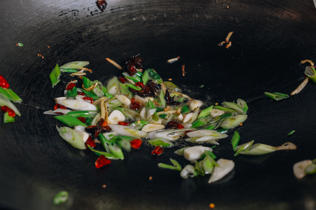 scallions, garlic, chilies, ginger, and star anise in wok