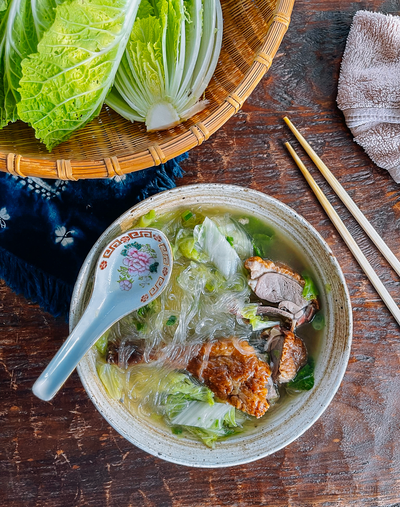 bowl of duck noodle soup with napa and glass noodles