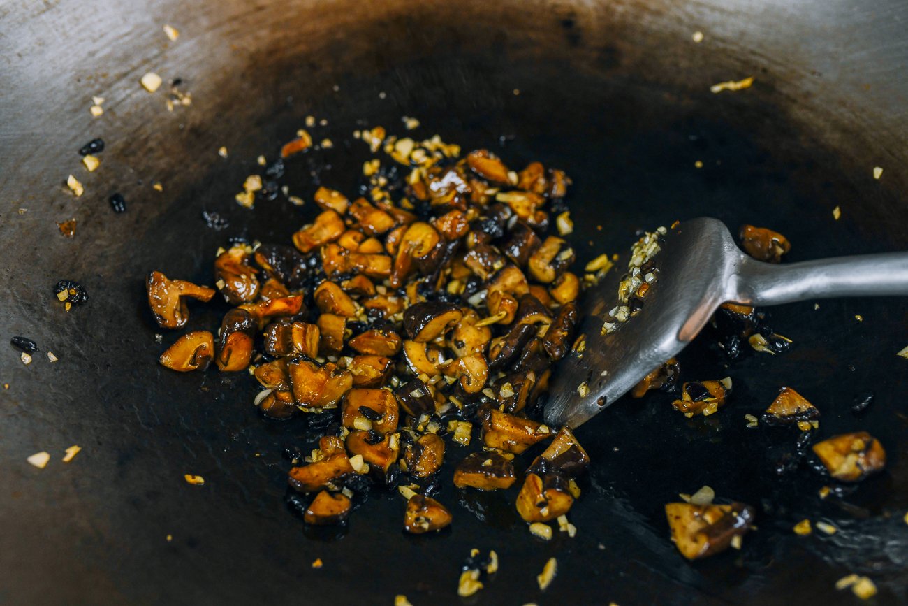 stir-frying mushrooms, garlic, and black beans