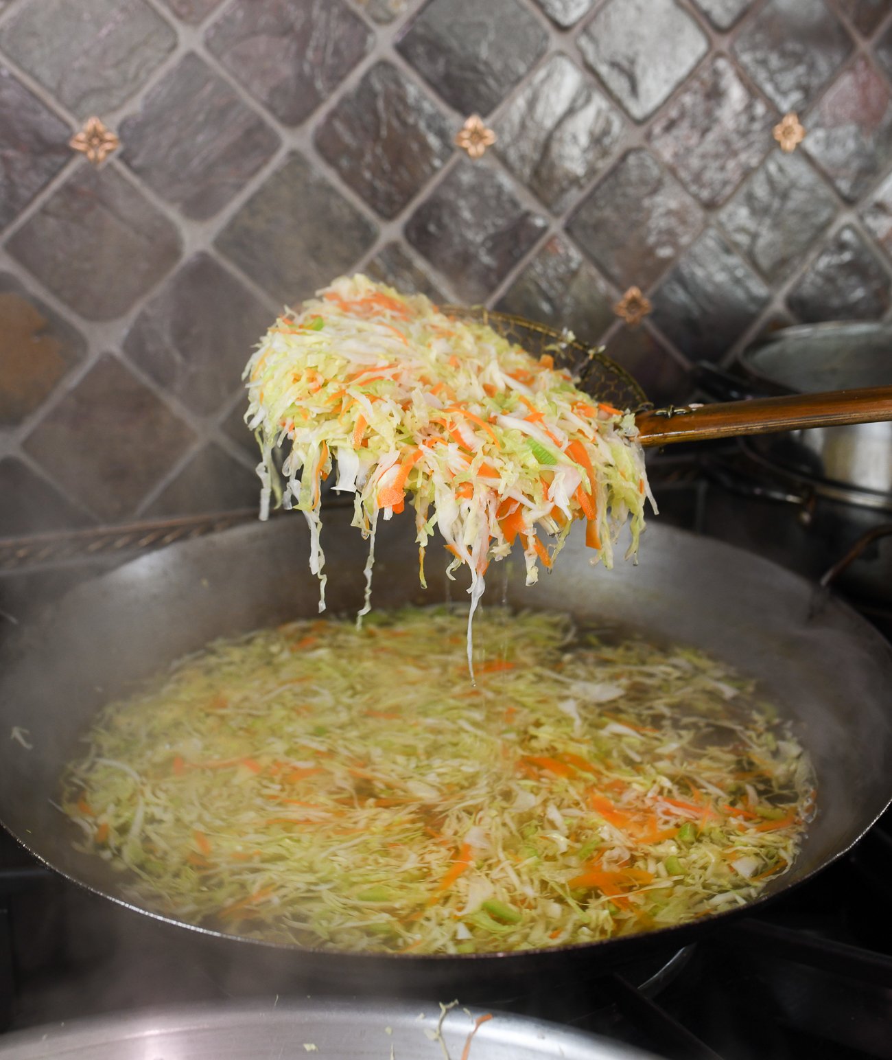 blanching shredded cabbage, carrots and celery in wok