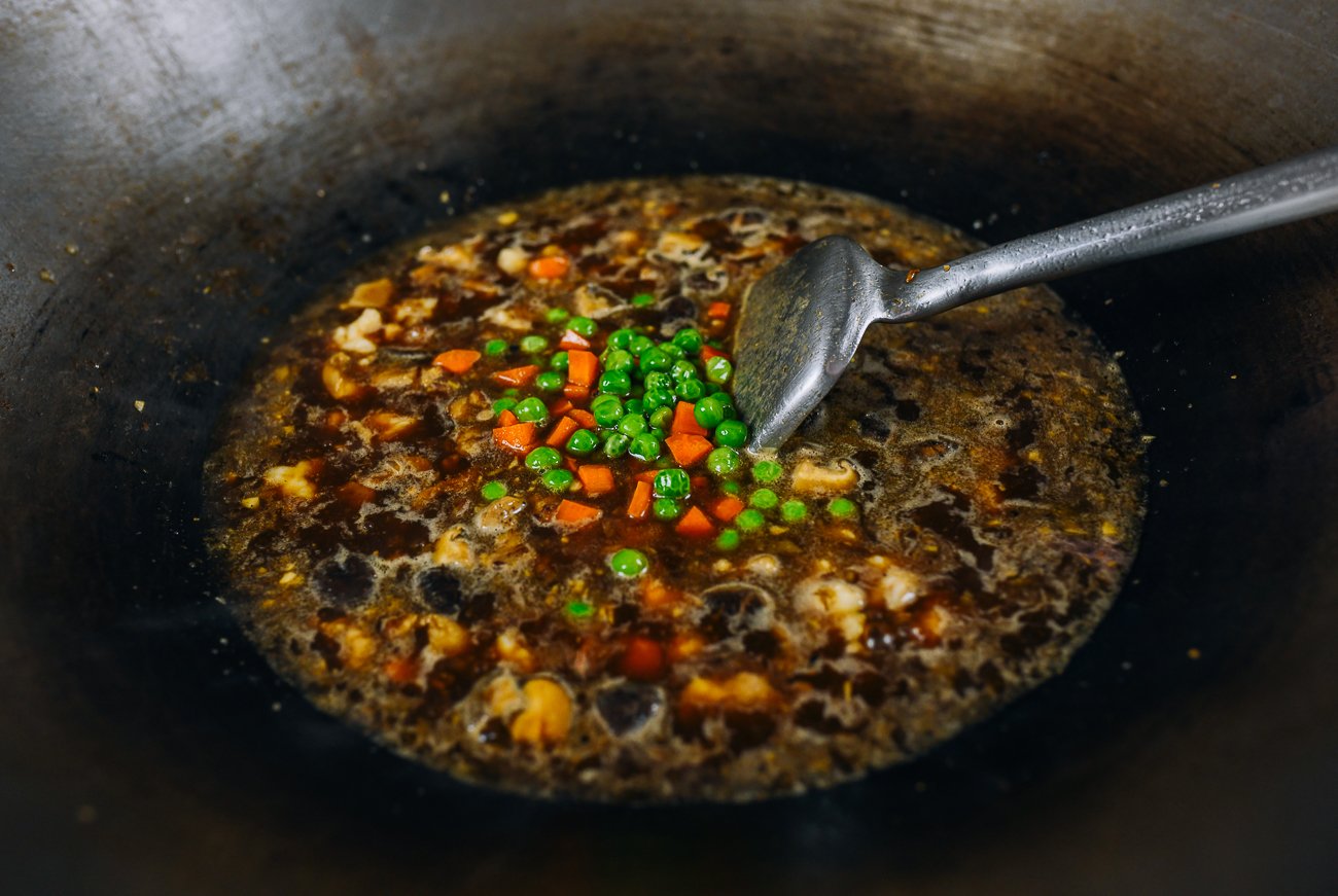 adding peas and carrots to fujian fried rice sauce mixture