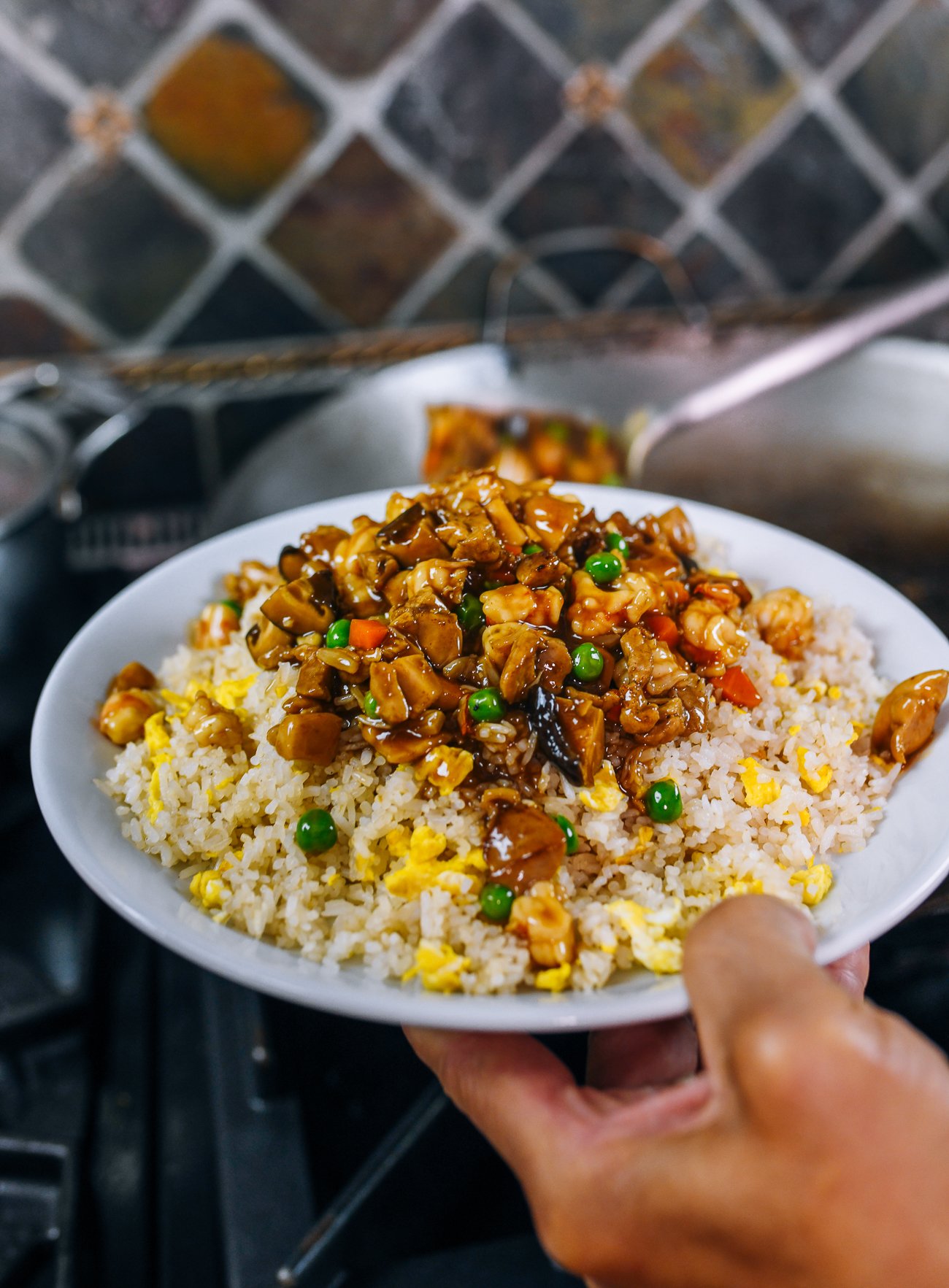 scooping sauce mixture onto fried rice