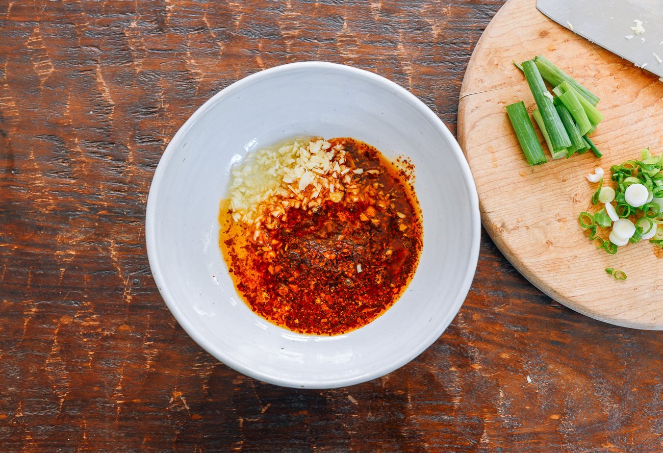 oil, garlic, and Sichuan chili flakes in white bowl