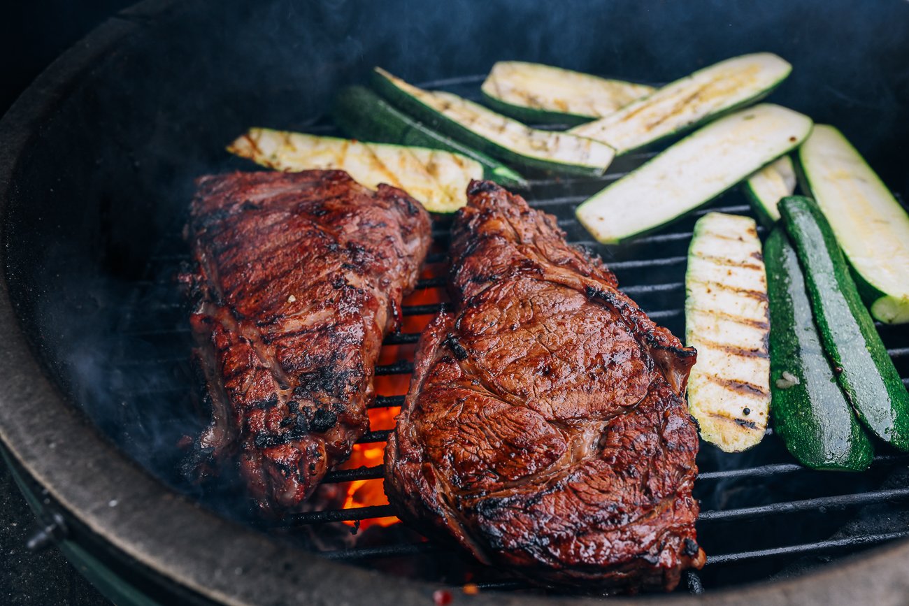 Ribeye steaks and zucchini on grill
