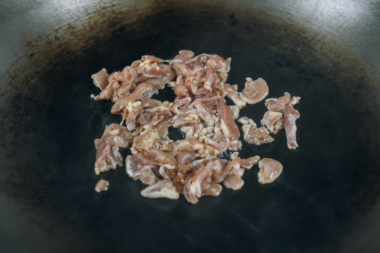 searing chicken pieces in hot wok