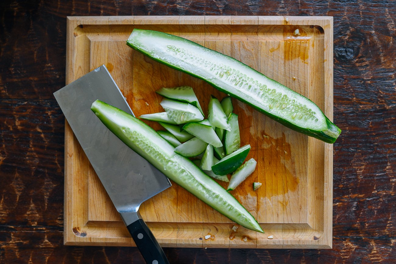 cutting cucumber on cutting board
