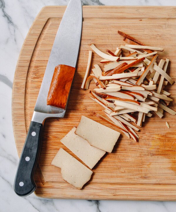 slicing pressed tofu or doufugan on cutting board