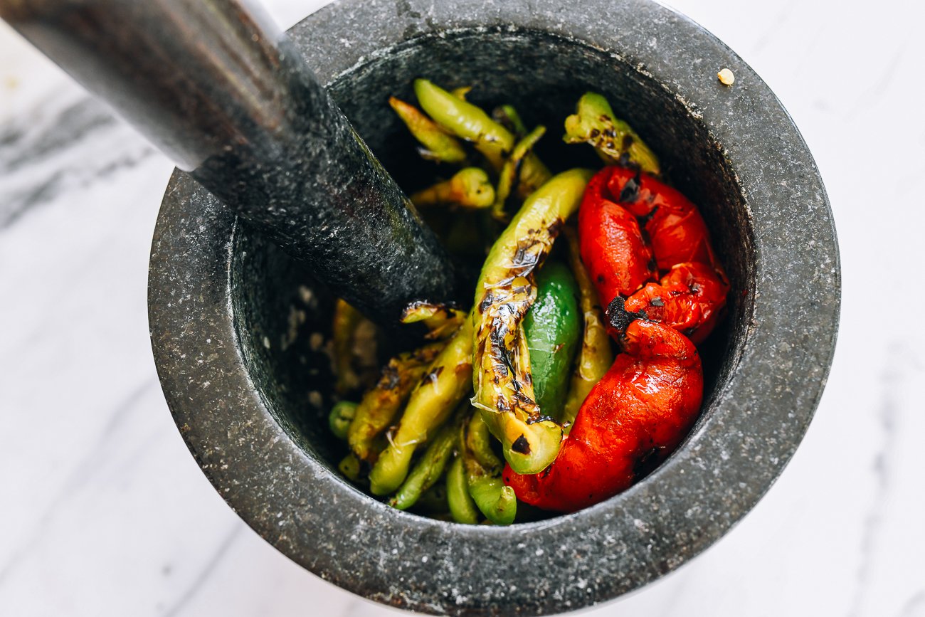 charred peppers in mortar and pestle