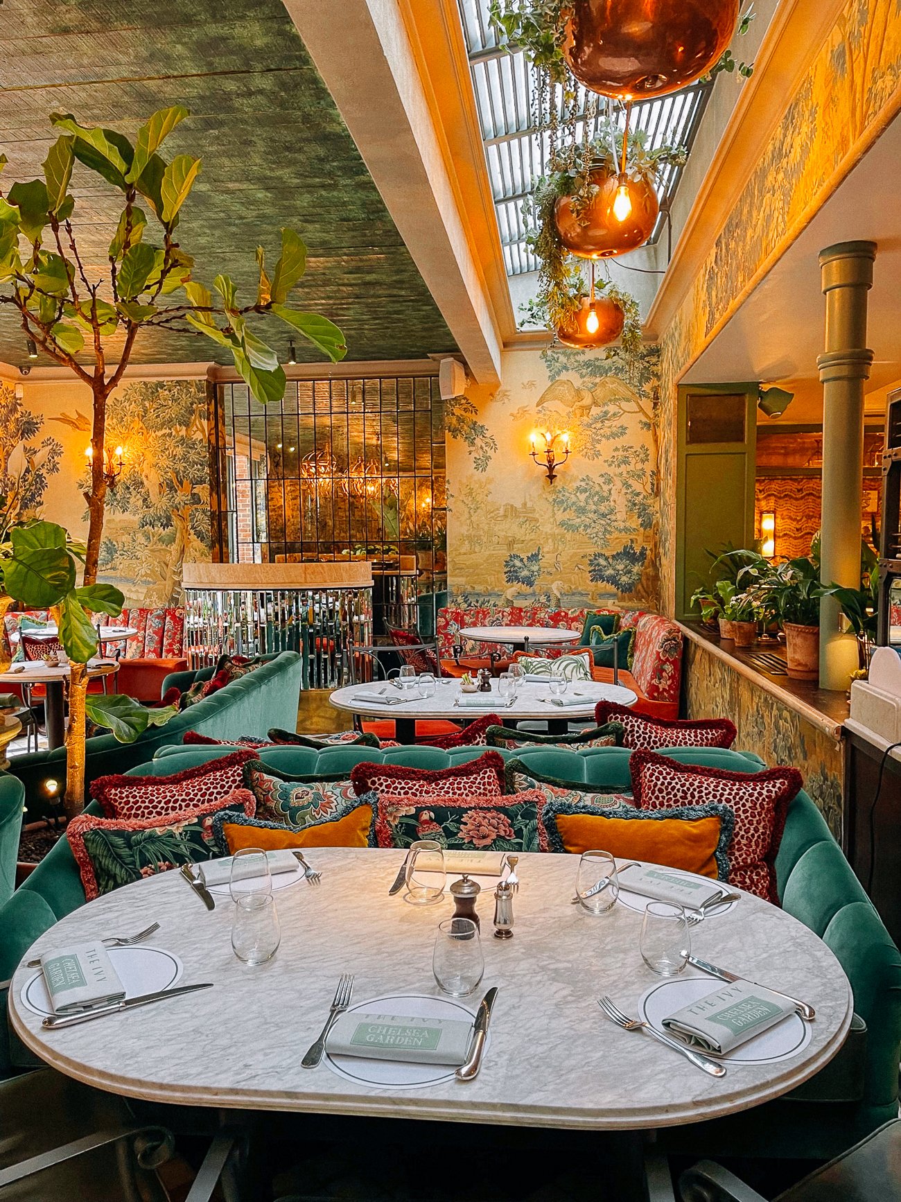 Ornate wallpapered floral, velvet, and gold dining room at The Ivy Chelsea Garden