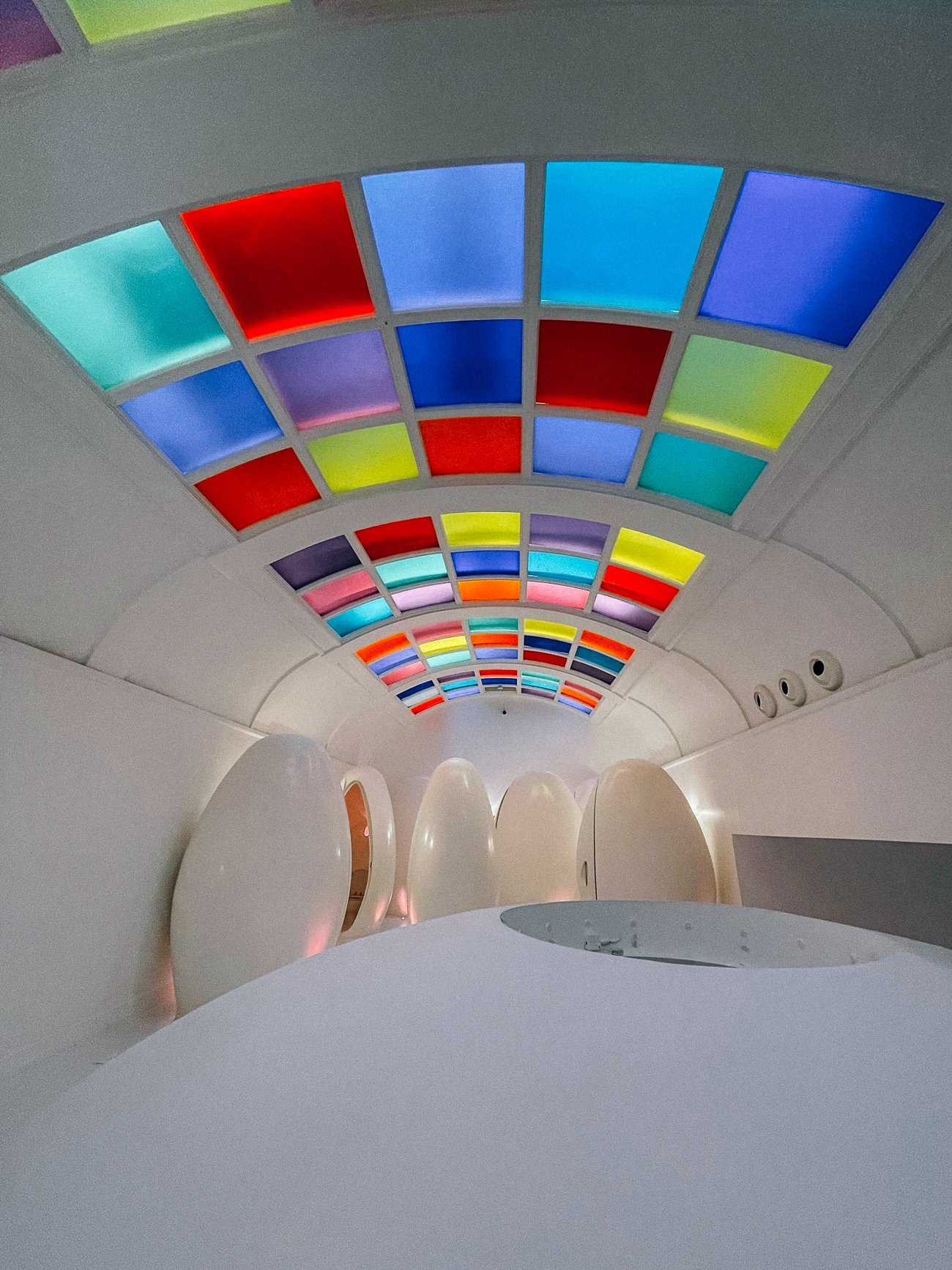 Technicolor ceiling and futuristic white egg-shaped toilet pods at sketch