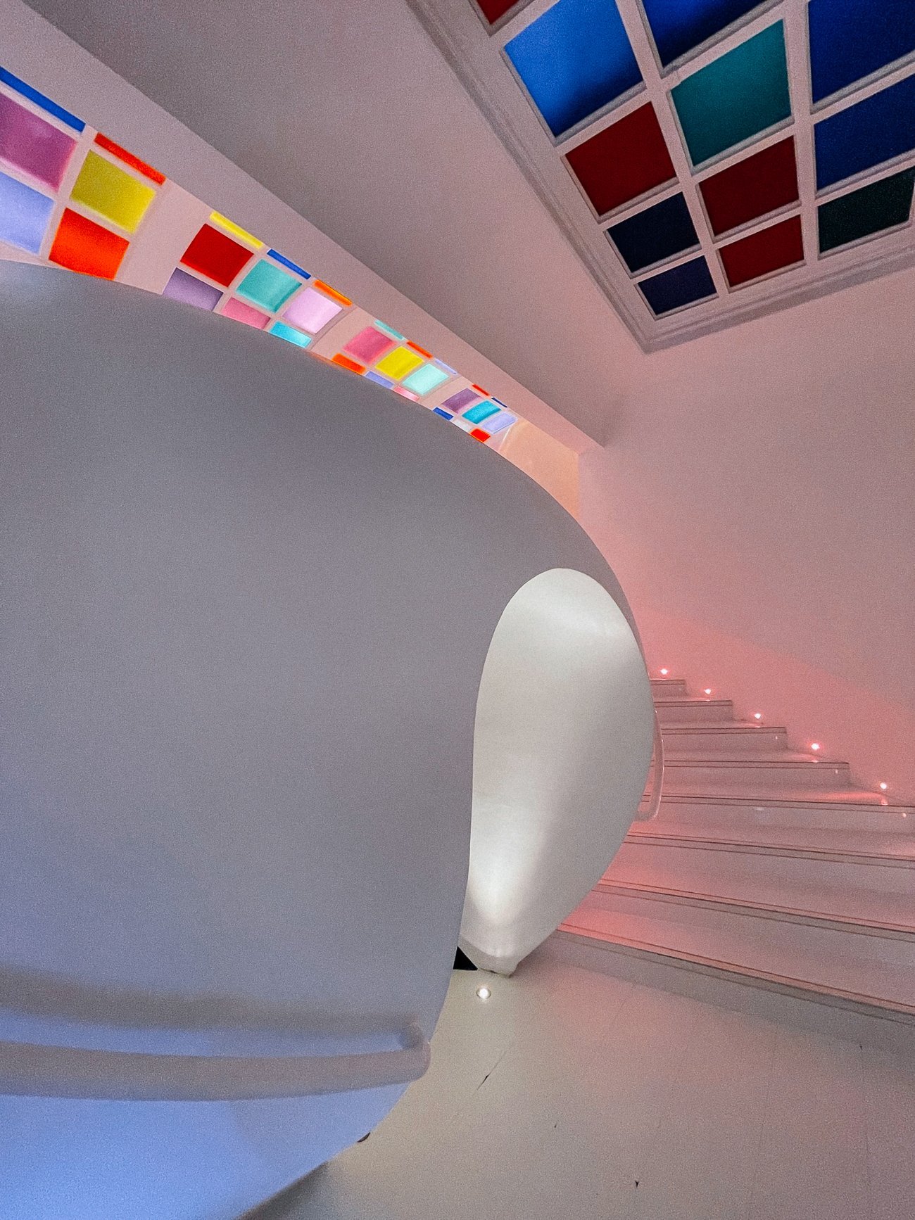 Technicolor ceiling and white bathroom at Sketch with curved staircase
