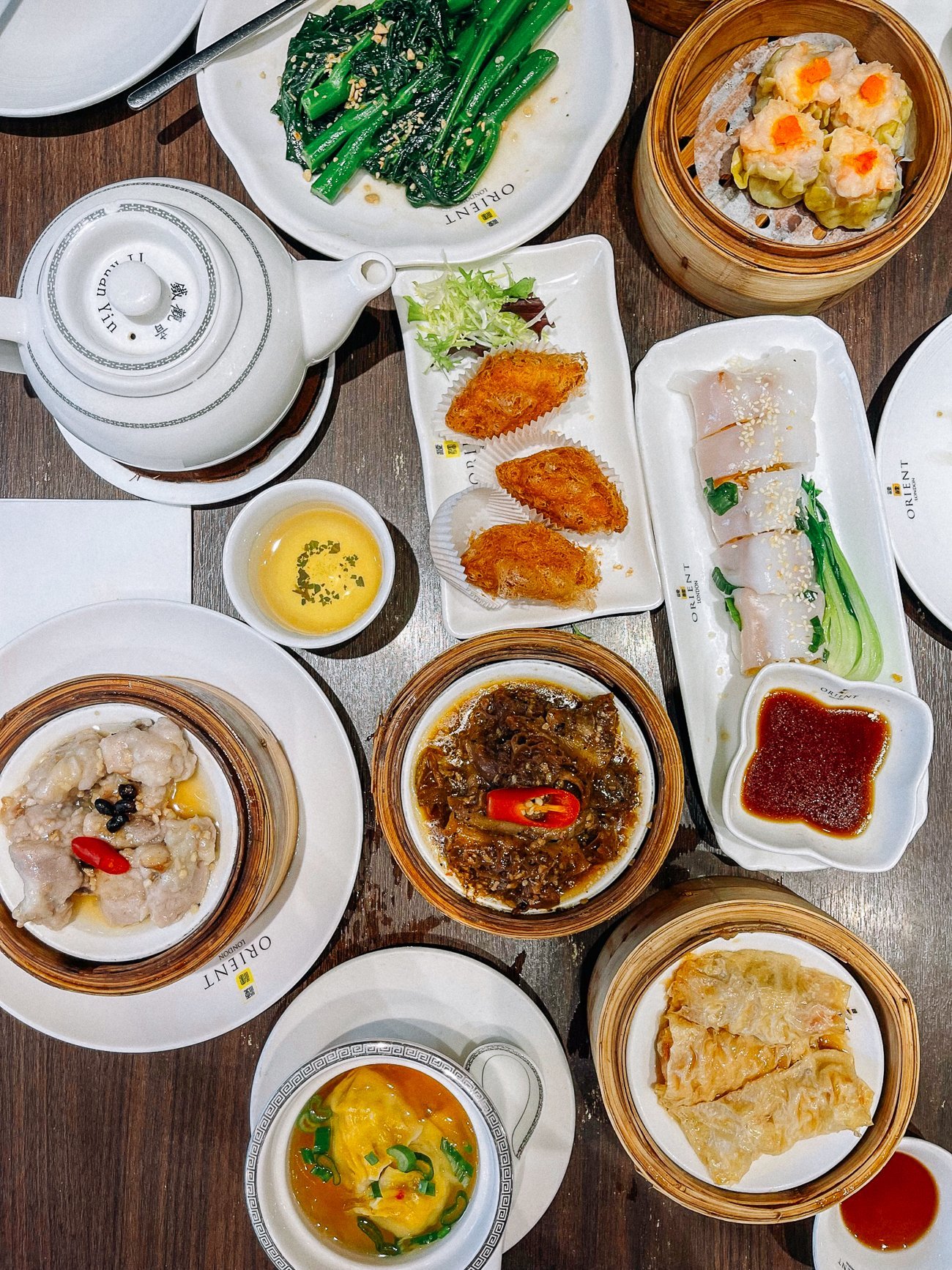 Overhead of dim sum spread with taro puffs, pork ribs, tofu rolls, beef shortribs, green gai lan and dumpling soup