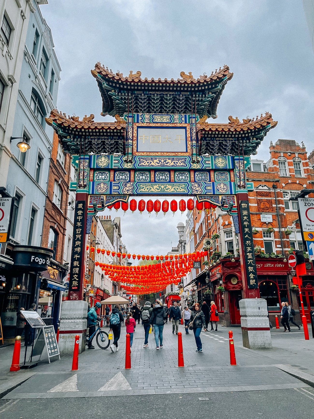 Gold, red and teal Chinatown welcome pagoda archway with red lanterns