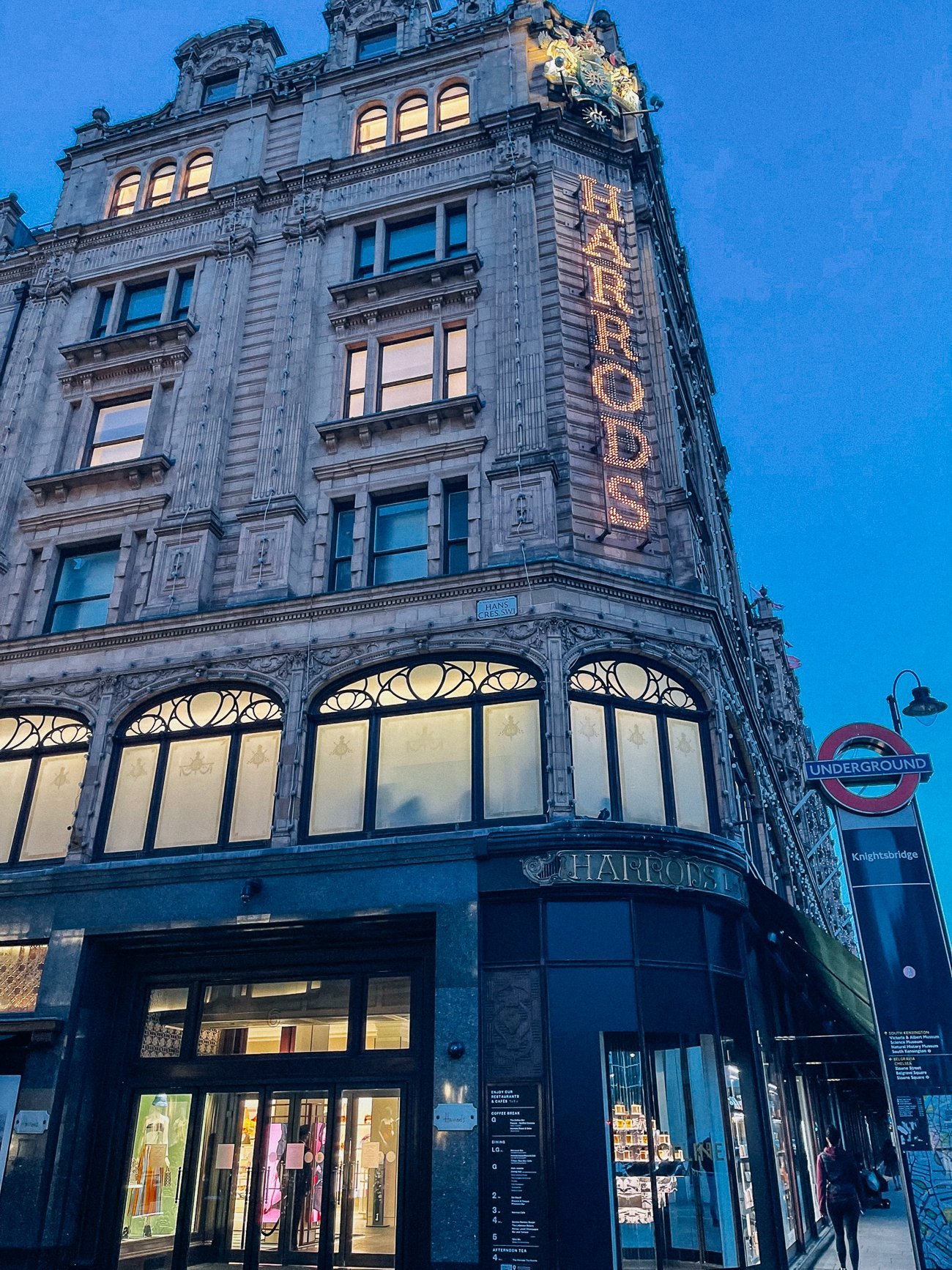 Harrods exterior at night with lit sign