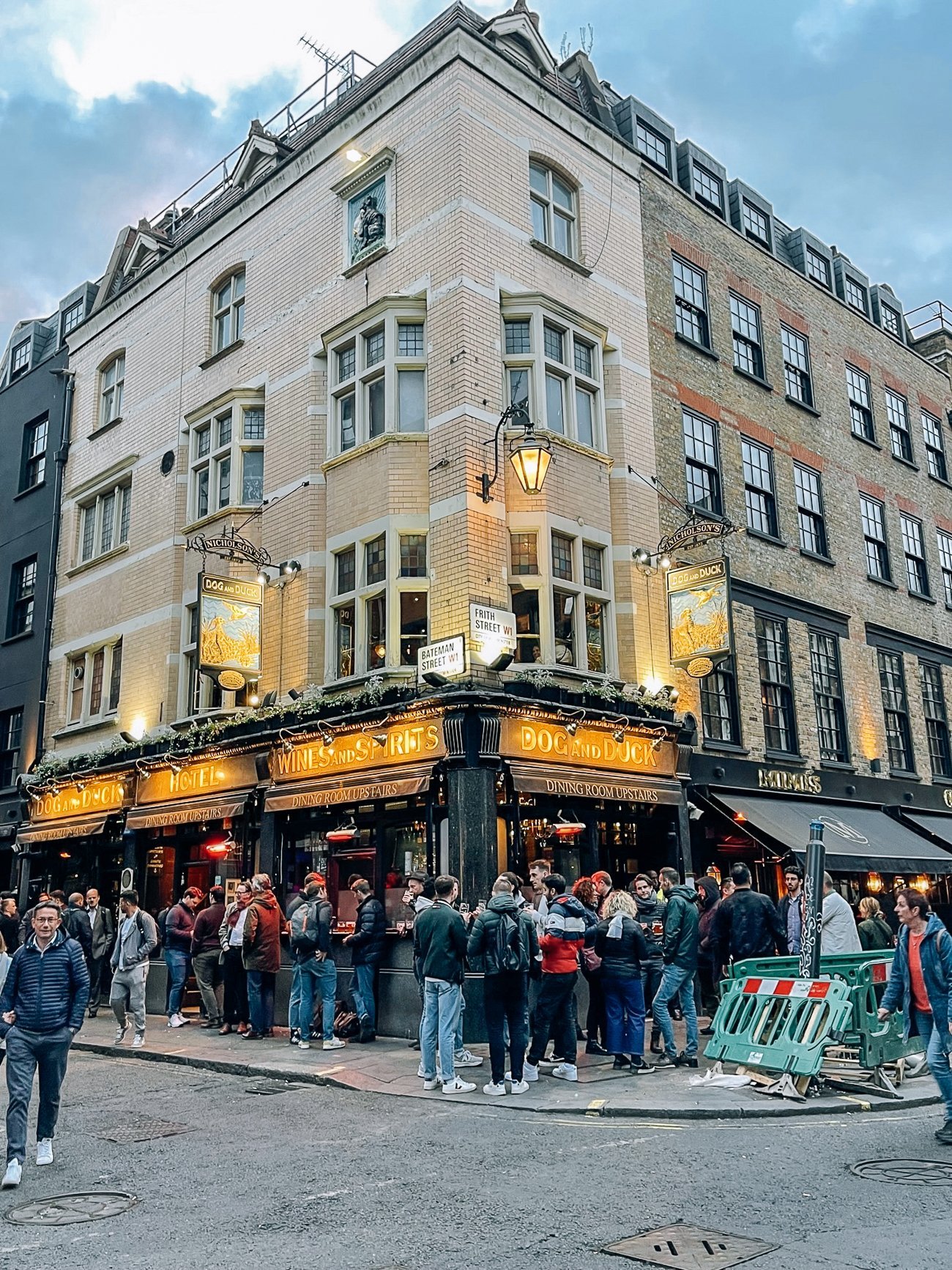 Crowded pub in the evening with people standing outside