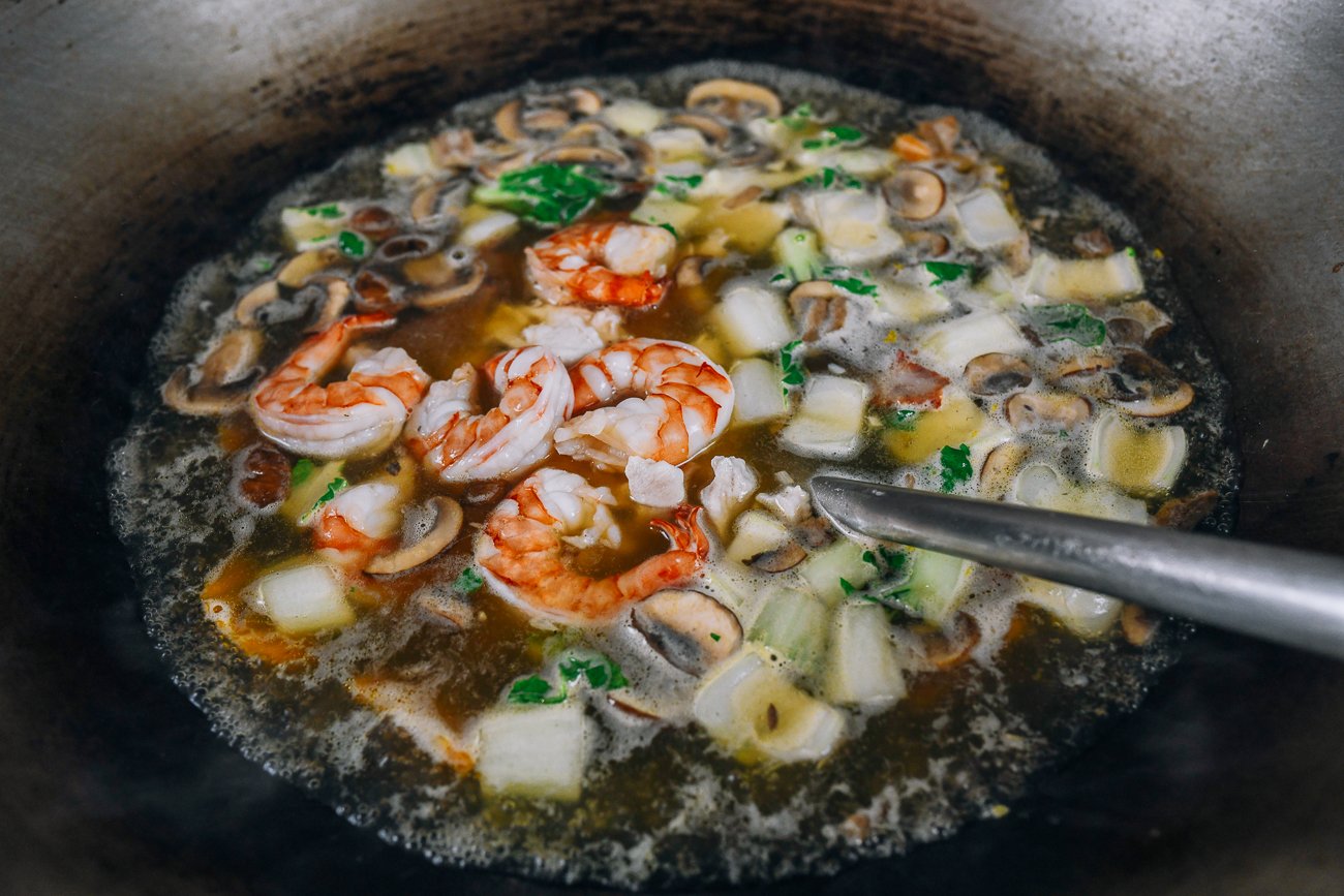 adding shrimp and other proteins to soup in wok