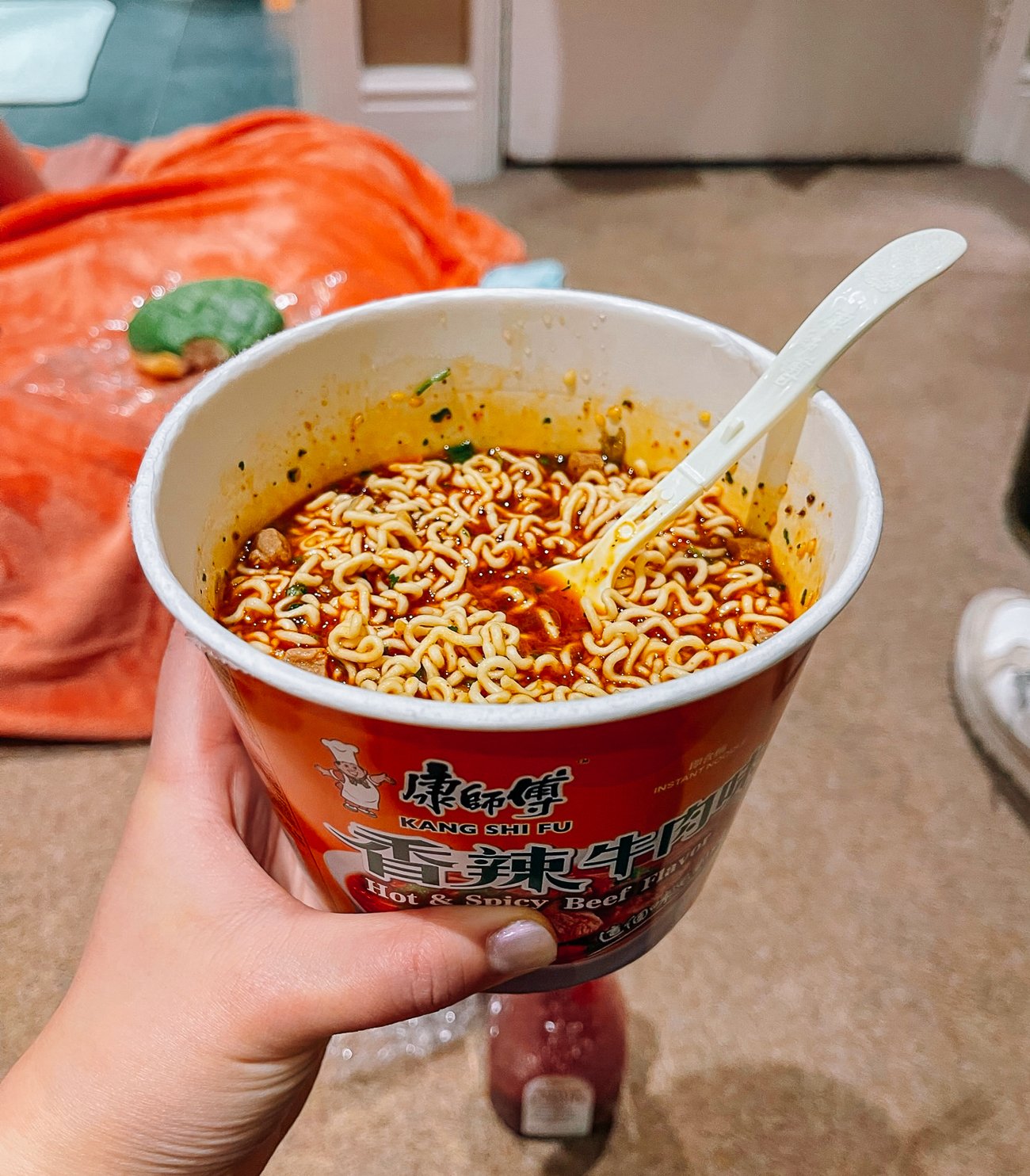 Cup of spicy beef instant noodles eaten on the floor