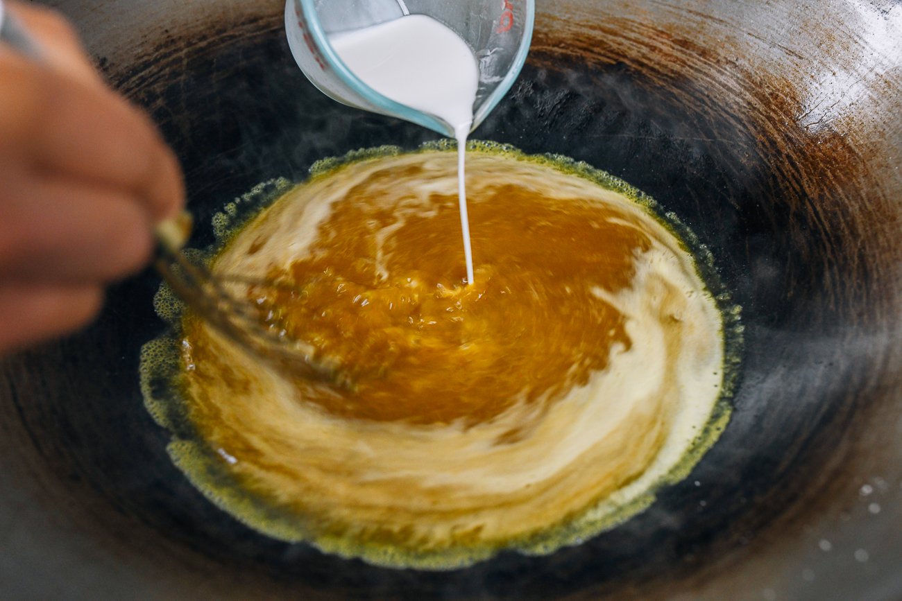 whisking cornstarch slurry into gravy mixture in wok
