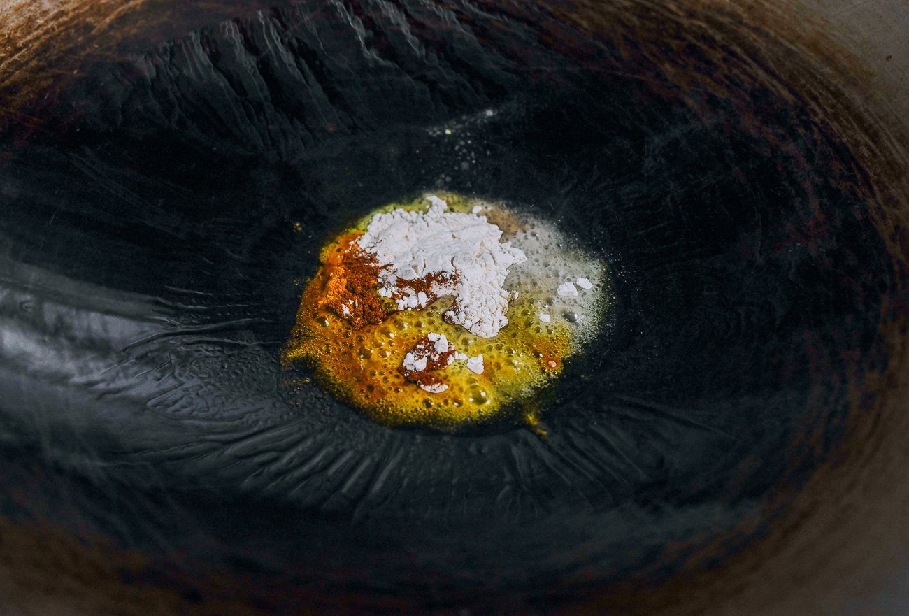 Oil, flour, turmeric, and paprika in wok