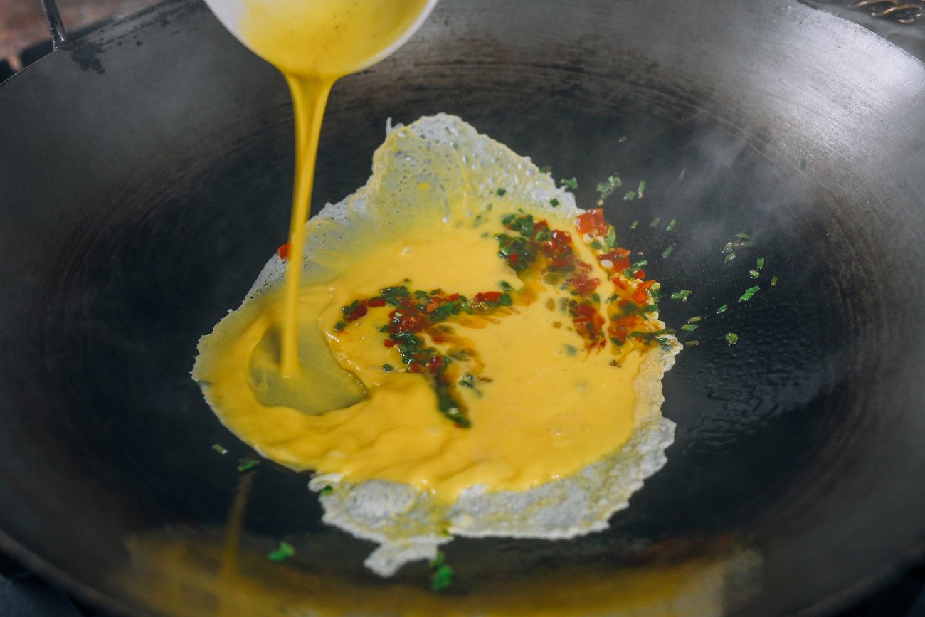 Pouring eggs into wok