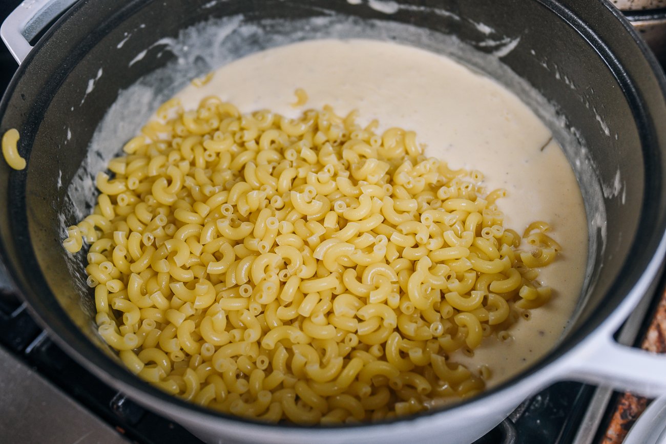 elbow macaroni added to cheese sauce