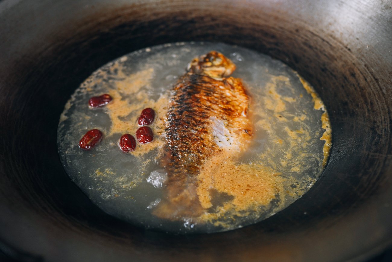 fish in wok with water and dried dates