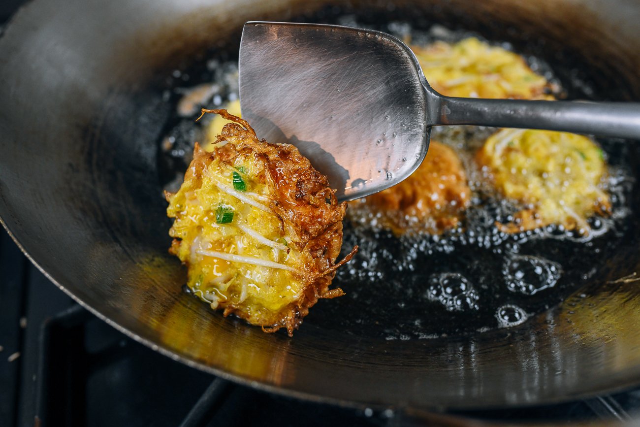 flipping an egg foo young patty in hot oil