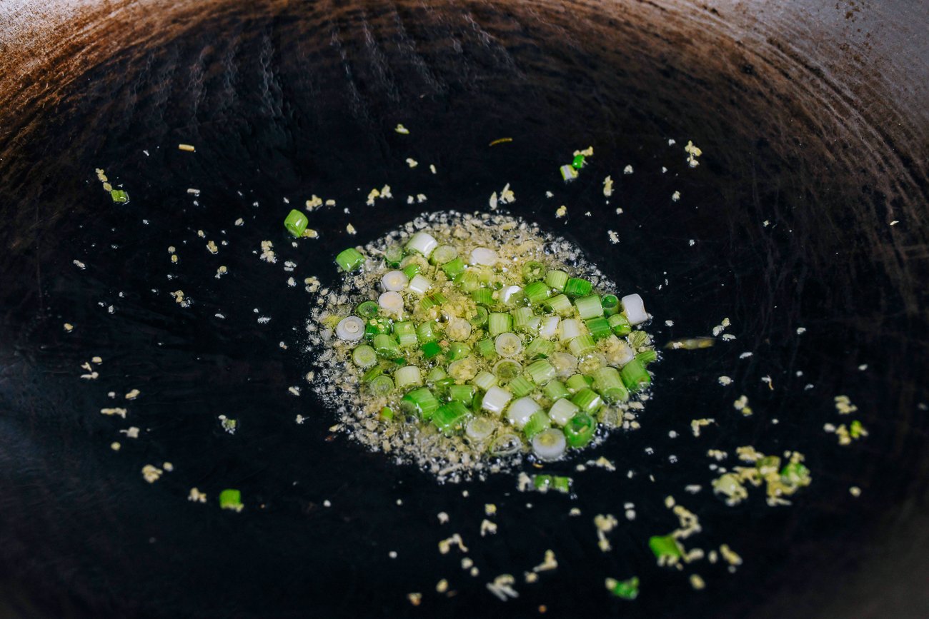 cooking scallions and minced ginger in oil in wok
