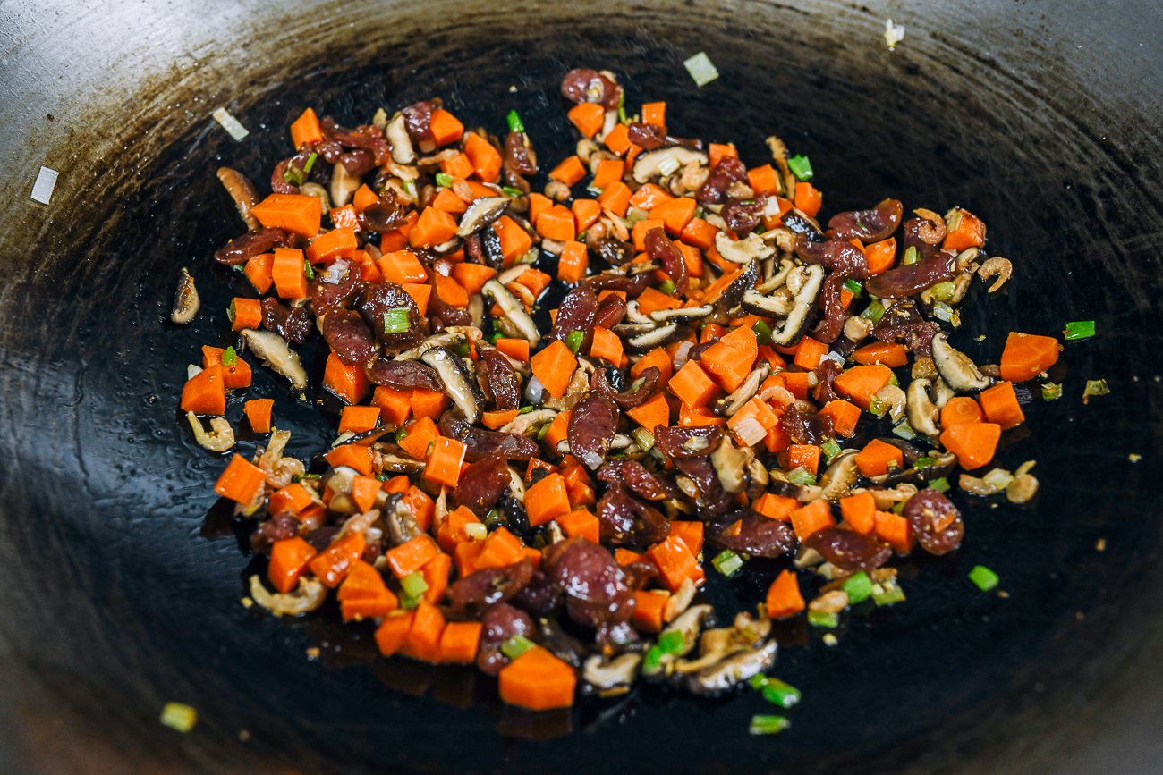 carrots, mushrooms, dried shrimp, Chinese sausage, and scallions in wok