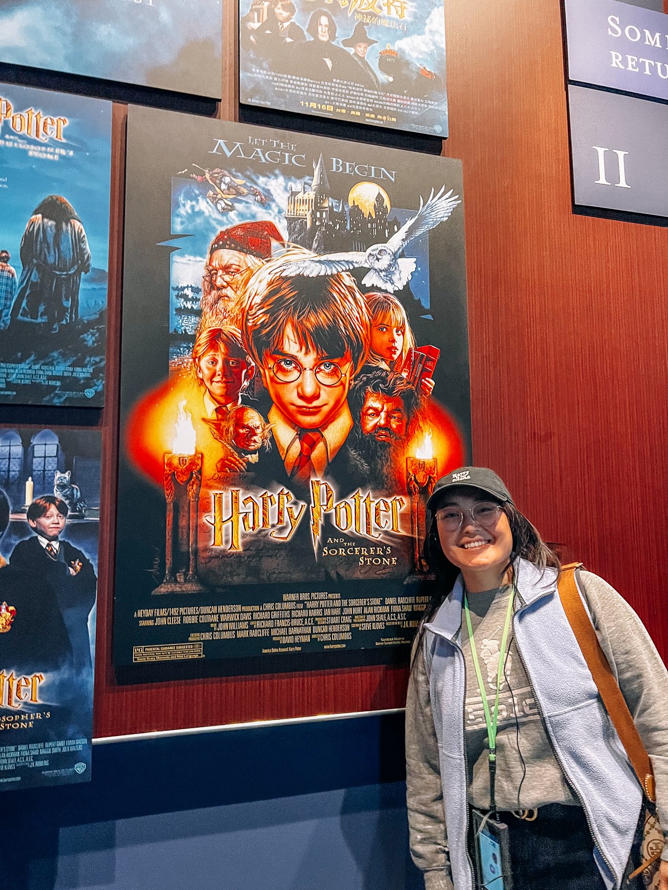 Kaitlin in front of the Harry Potter and the Sorcerer's Stone movie poster at Harry Potter studio tour