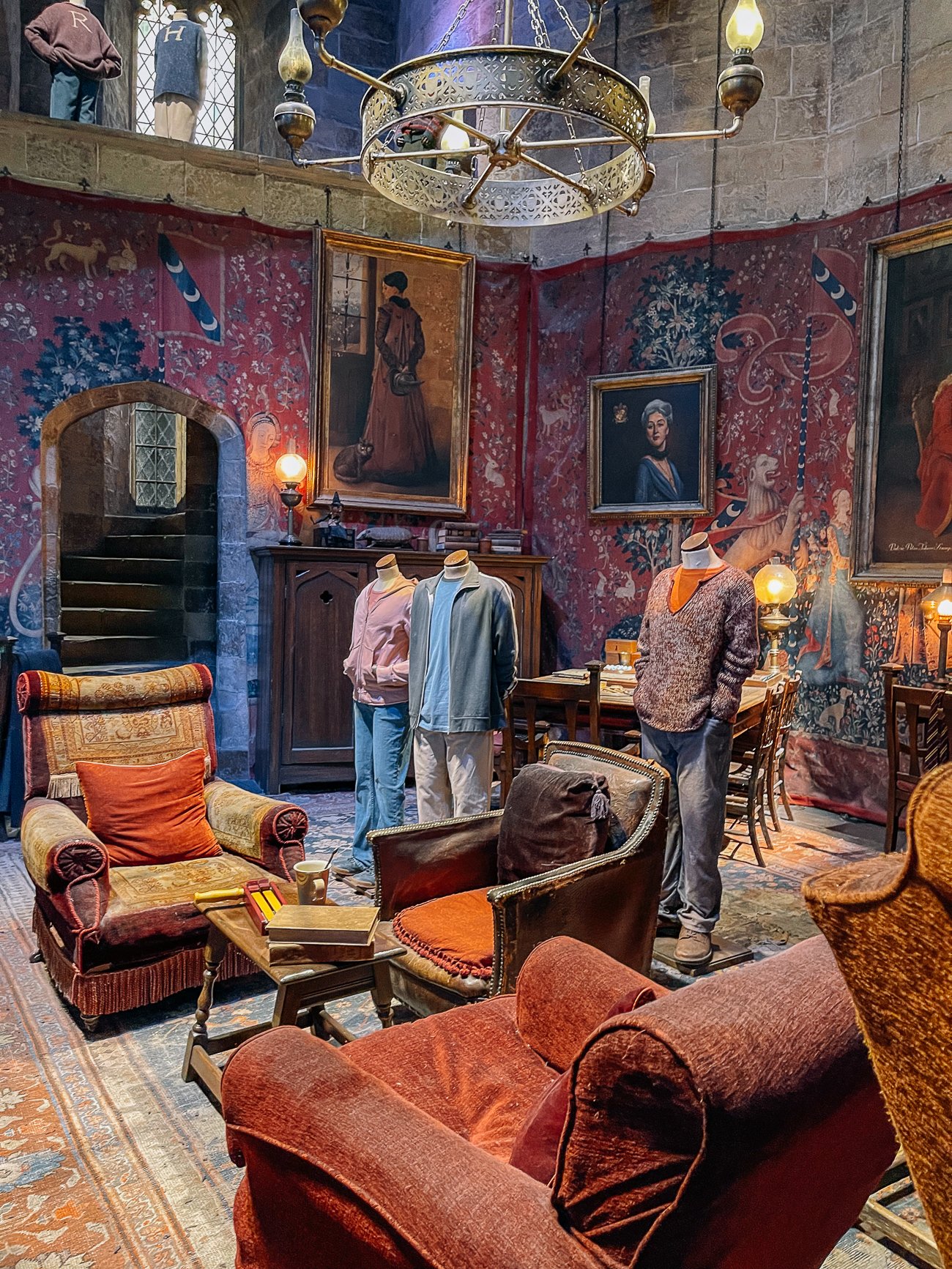 The Gryffindor common room at Harry Potter studio tour with Harry, Ron, and Hermione third movie mannequins.