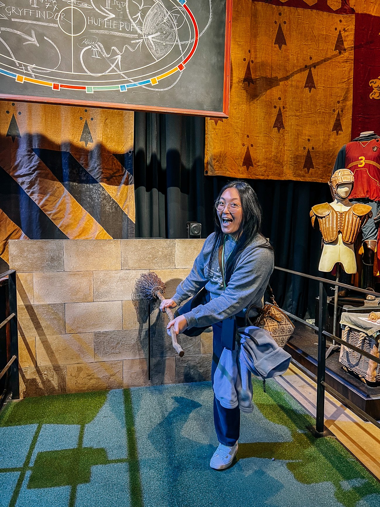 Kaitlin getting on a broomstick at Harry Potter studio tour
